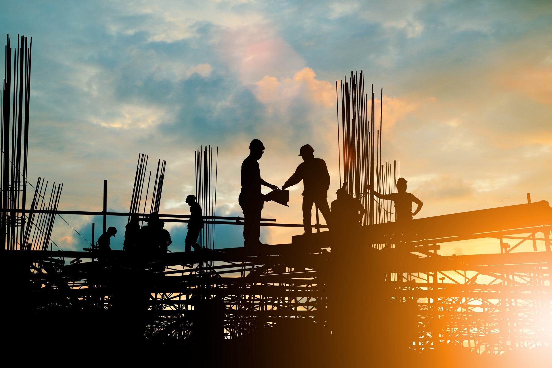 Silhouette of engineer and construction team working at site over blurred background sunset pastel for industry background with Light fair.Create from multiple reference images together.